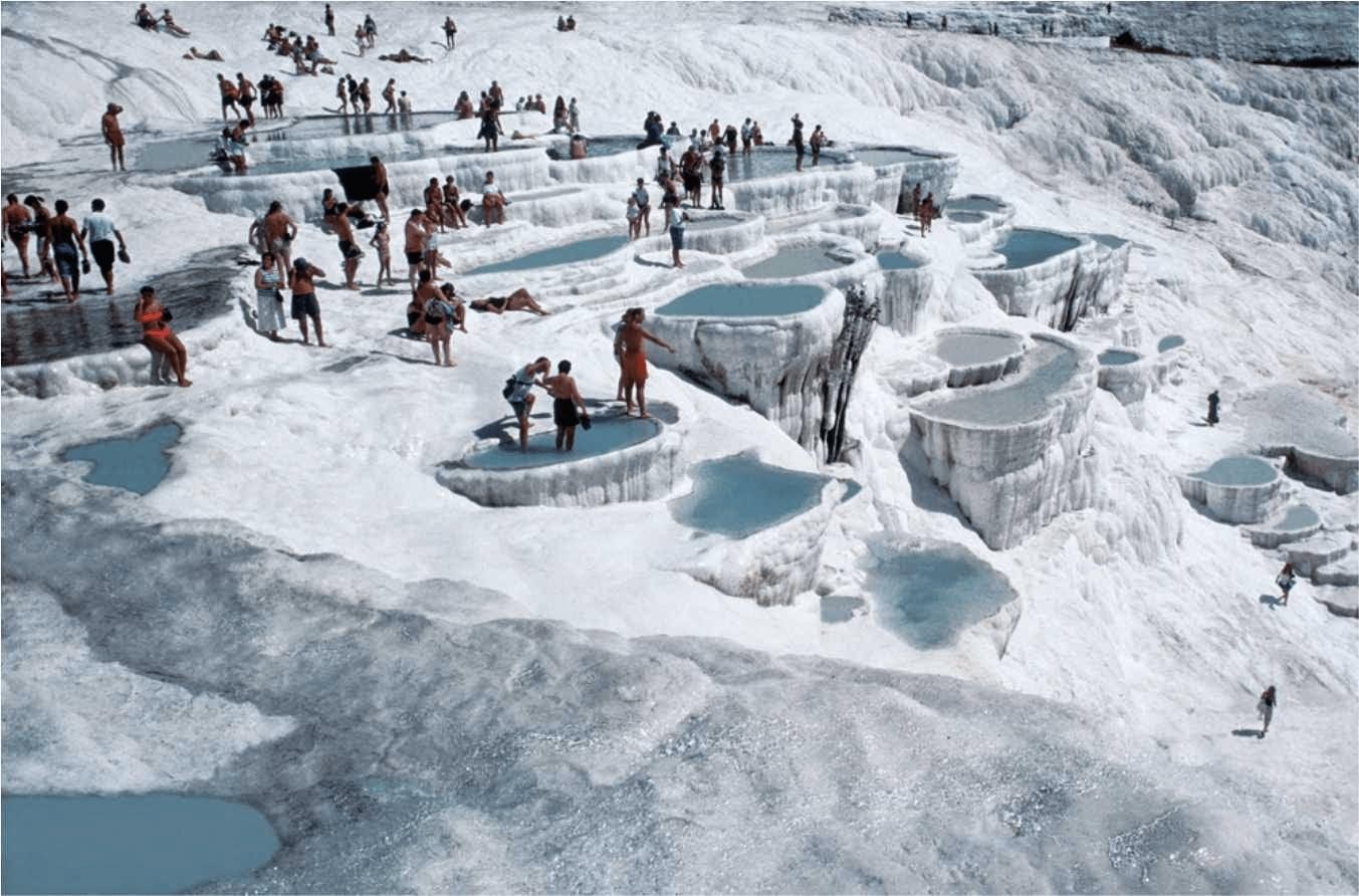 Visitors bathing in the white travertine terrace pools at Pamukkale