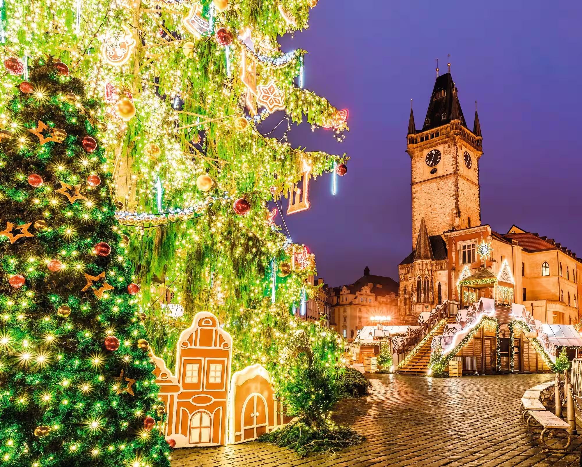 The Christmas tree lit at night beside the astronomical clock tower on Prague's Old Town Square
